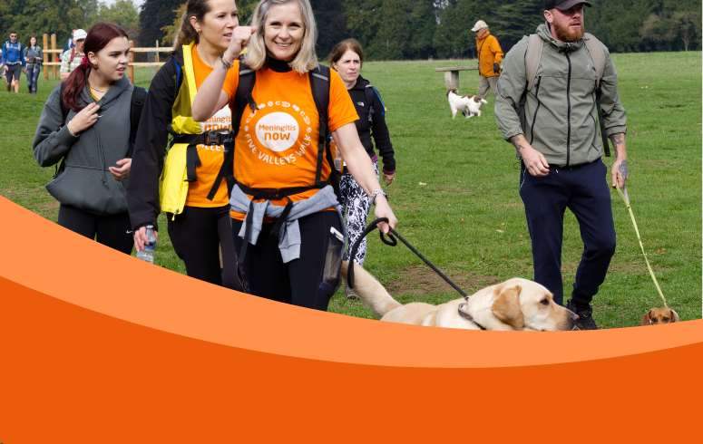 Group of walkers with dogs and front woman wearing Meningitis Now t-shirt