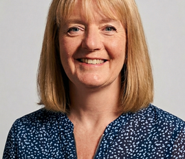 A blonde haired woman wearing a navy blouse