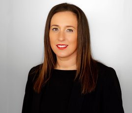 A woman with brown hair and red lipstick looking at the camera.