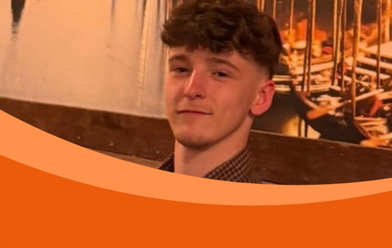 Portrait of a young man with curly brown hair in a restaurant, looking calmly at the camera; an orange curved graphic covers the lower frame.