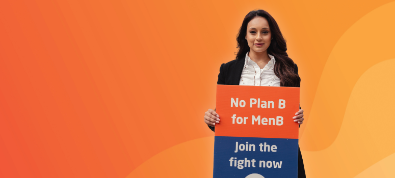 Smiling businesswoman in a black blazer holds a MenB campaign sign reading “No Plan B for MenB. Join the fight now” on an orange background.