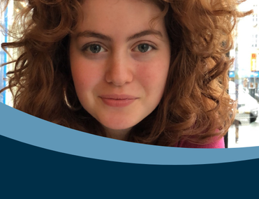 Young woman with curly auburn hair looking at camera